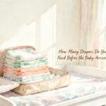 stack of newborn diapers next to size 1 diapers on a white changing table